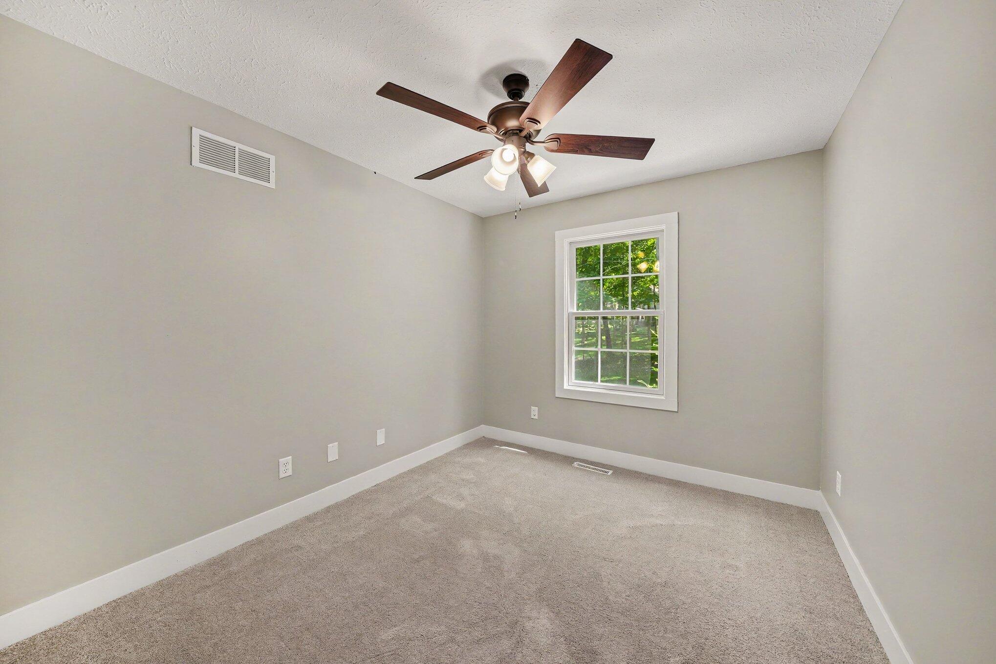 7563 East 400 North Rolling Prairie, IN 46371 - Photo 10 of 17 an empty room with windows and fan