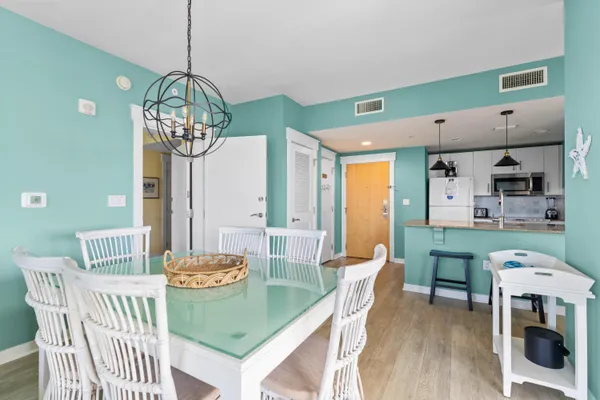 a view of a dining room with furniture a chandelier and wooden floor
