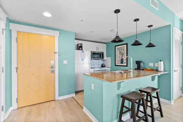 a kitchen with stainless steel appliances granite countertop a sink a refrigerator and a stove