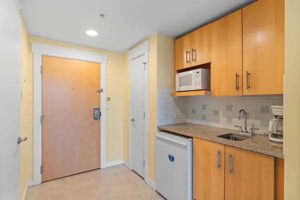 a kitchen with stainless steel appliances granite countertop a sink and cabinets with wooden floor