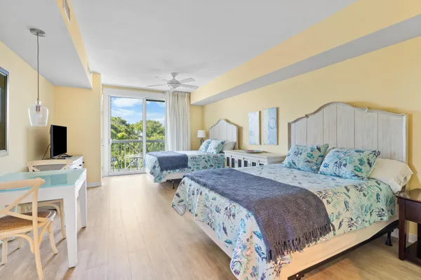 a bedroom with a large bed and a flat tv screen on dresser