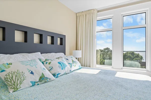 a bedroom with a bed painting and a window