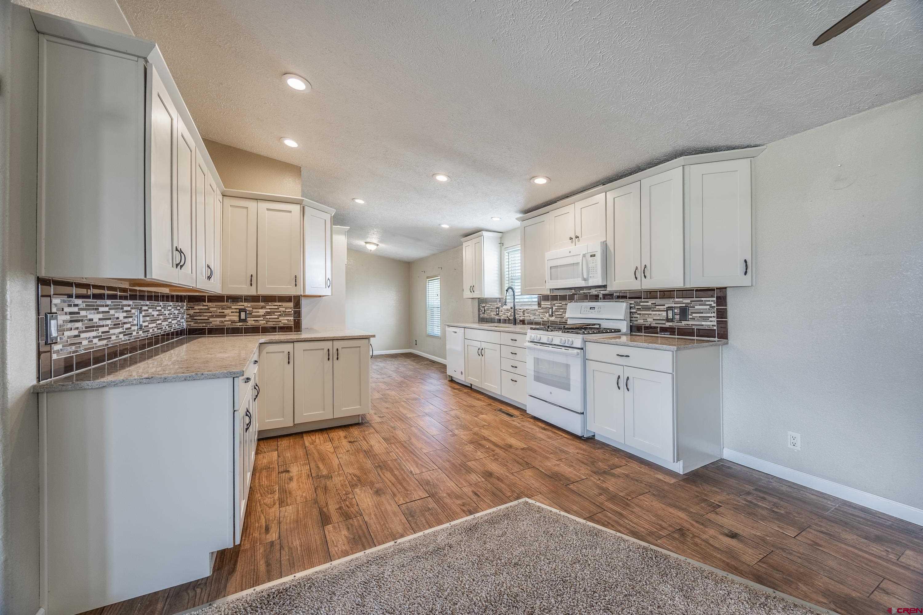 17377 Breeze Road Delta, CO 81416 - Photo 16 of 45 a kitchen with stainless steel appliances granite countertop a stove a sink and white cabinets