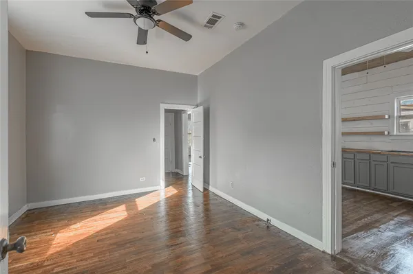 a view of a room with a ceiling fan and wooden floor