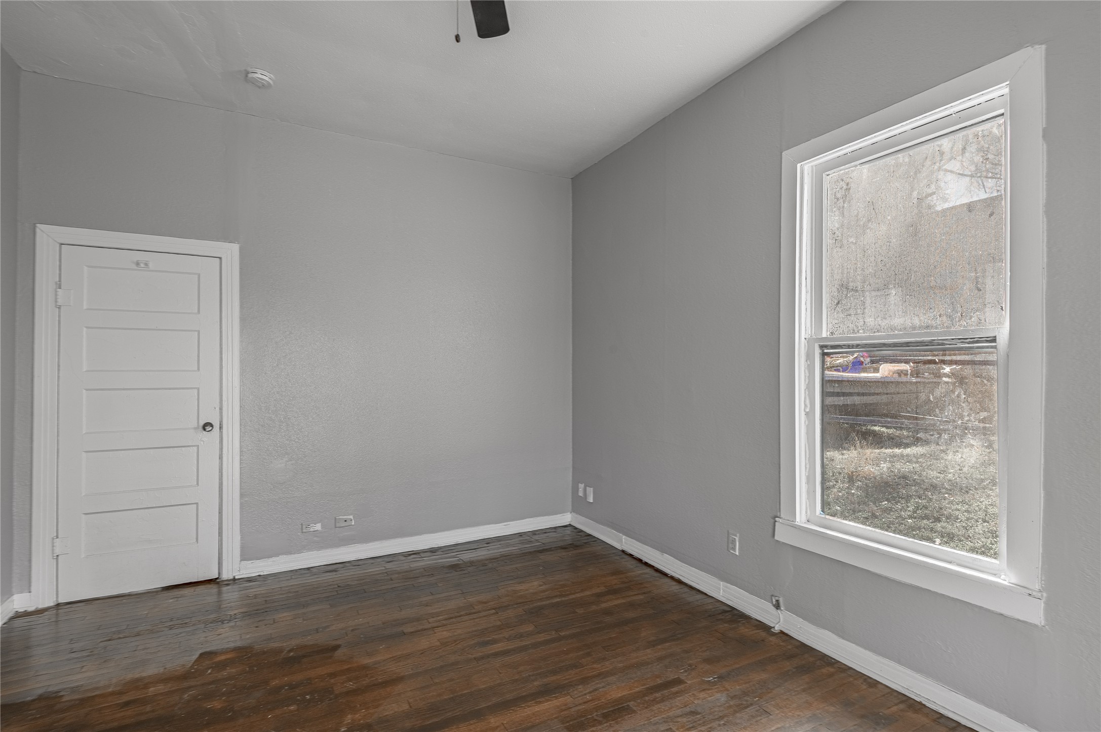 703 Avenue J Huntsville, TX 77320 - Photo 21 of 26 a view of an empty room with wooden floor and a window