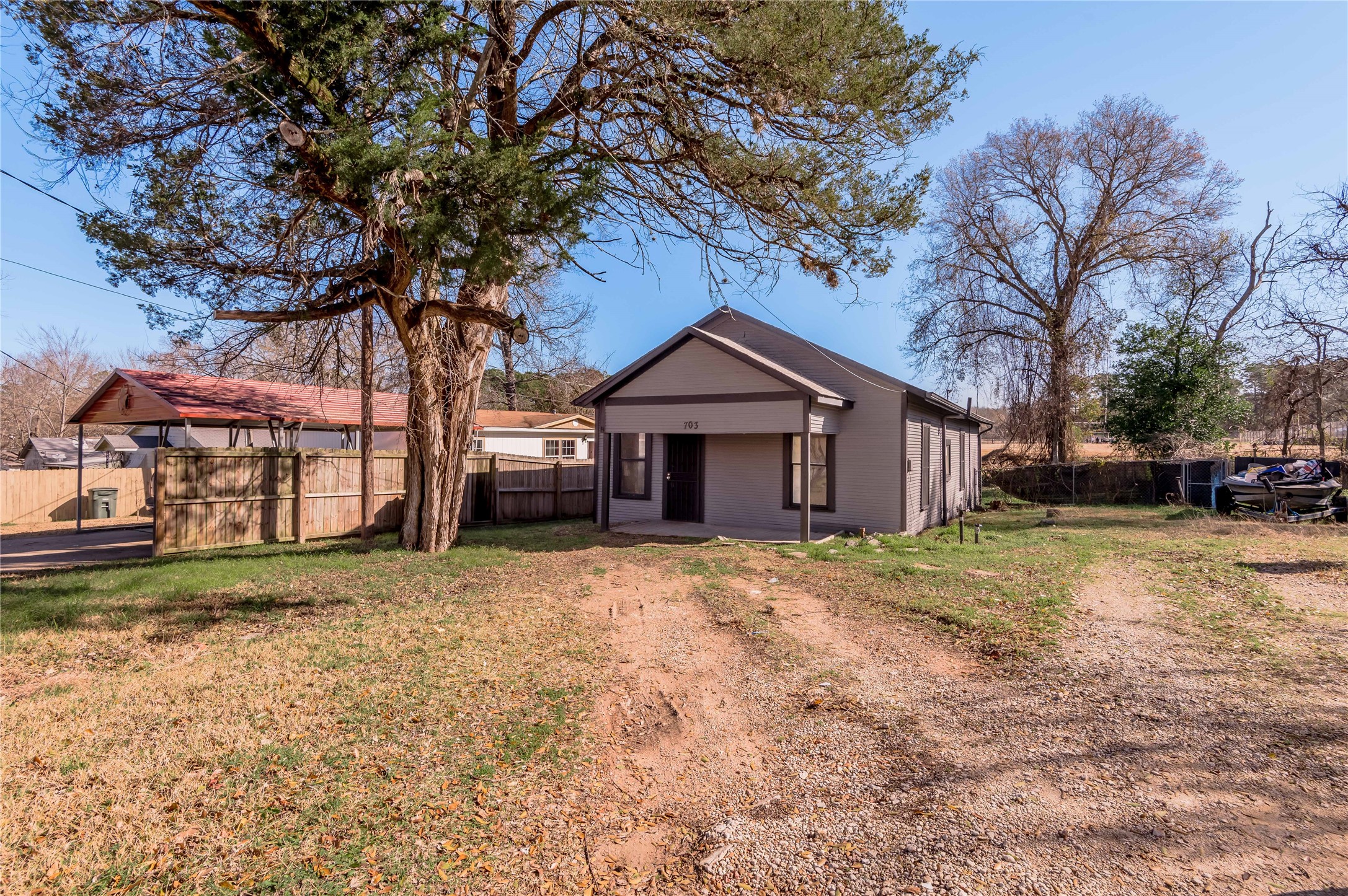 703 Avenue J Huntsville, TX 77320 - Photo 23 of 26 a house with trees in the background