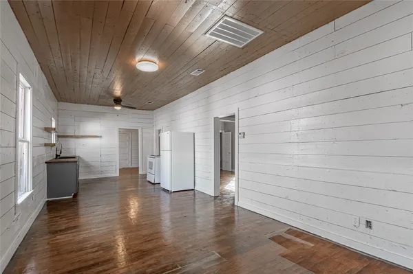 wooden floor in an empty room with a kitchen