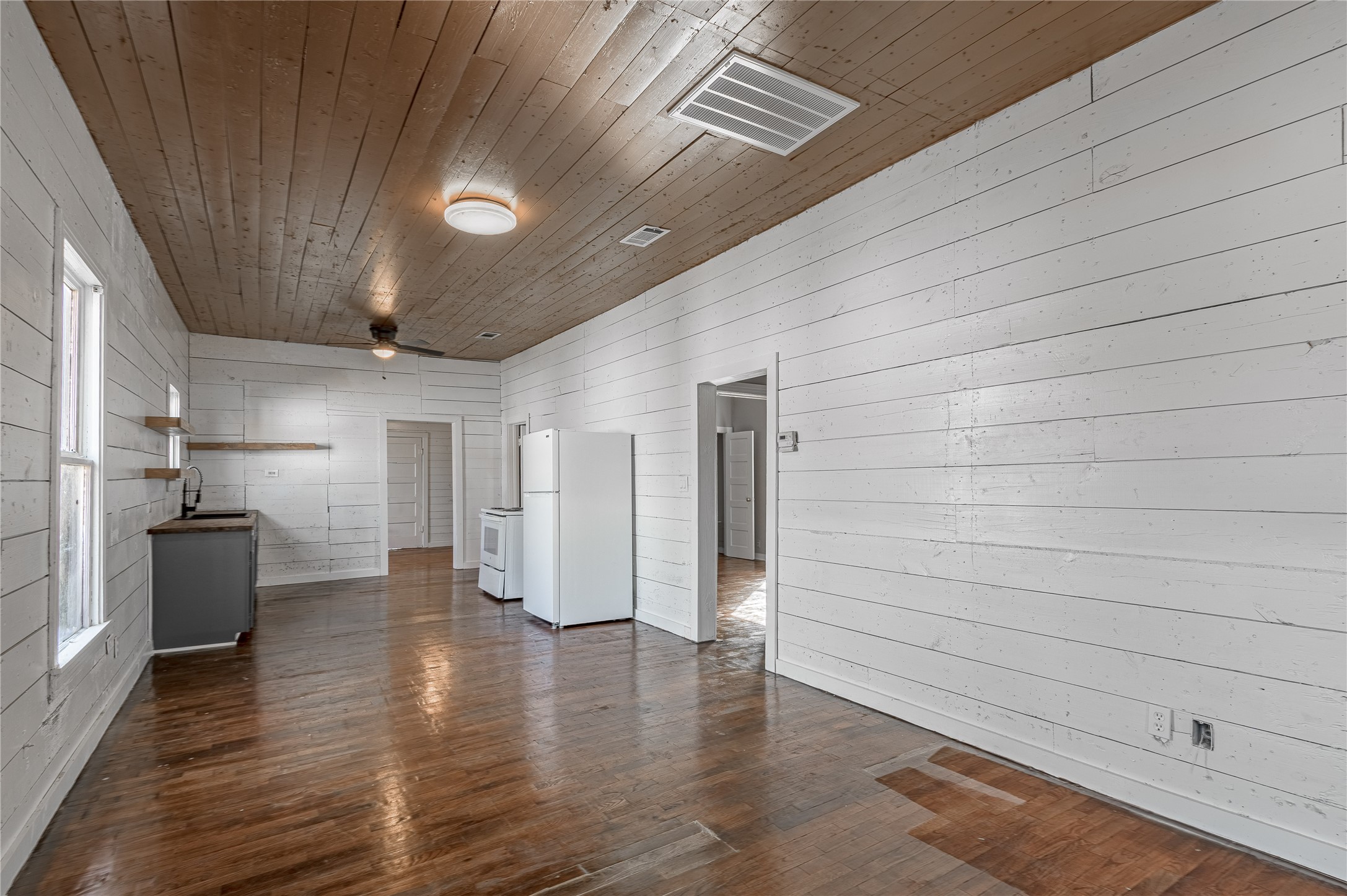 703 Avenue J Huntsville, TX 77320 - Photo 6 of 26 wooden floor in an empty room with a kitchen
