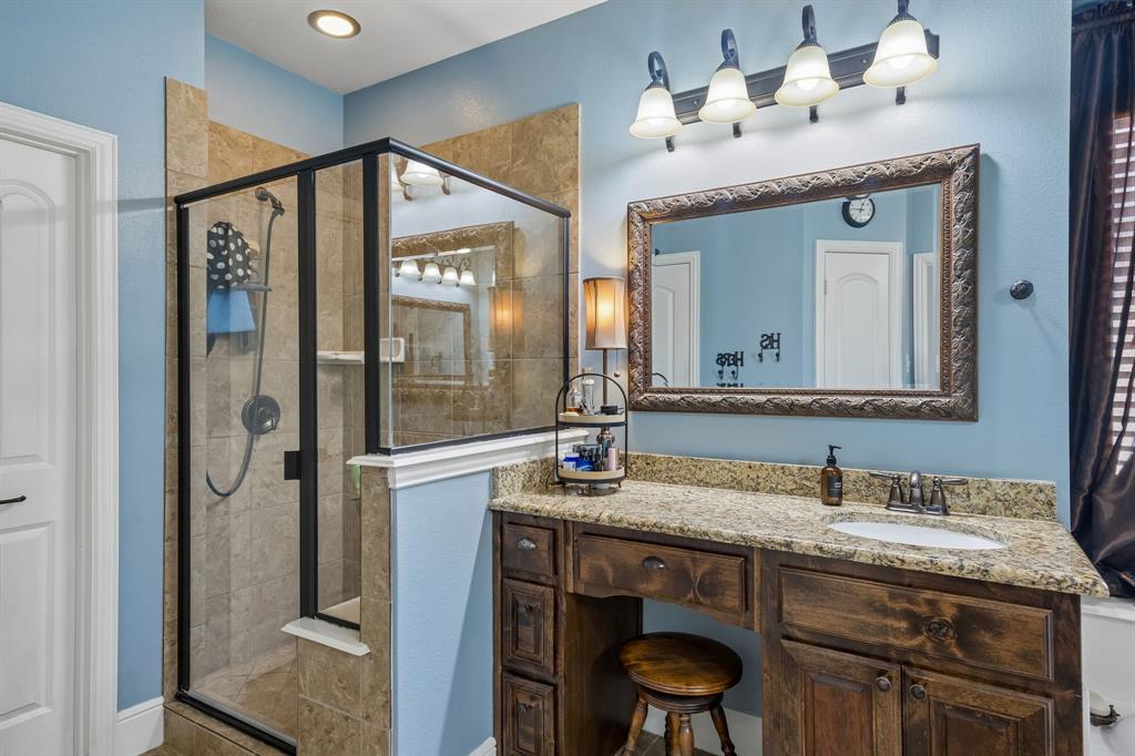8104 Red Riv Run North Richland Hills, TX 76180 - Photo 17 of 38 a bathroom with a granite countertop sink a mirror and a shower