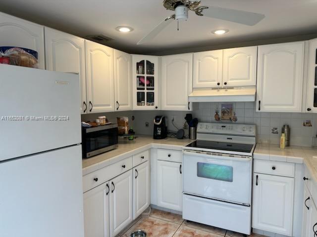 4716 Southwest 67th Avenue, Unit D2 Miami, FL 33155 - Photo 3 of 10 a kitchen with stainless steel appliances white cabinets and a refrigerator