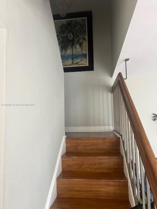 4716 Southwest 67th Avenue, Unit D2 Miami, FL 33155 - Photo 4 of 10 a view of staircase with wooden floor and white walls