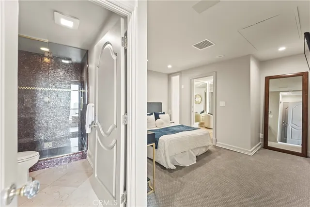 a spacious bedroom with a bed and glass door