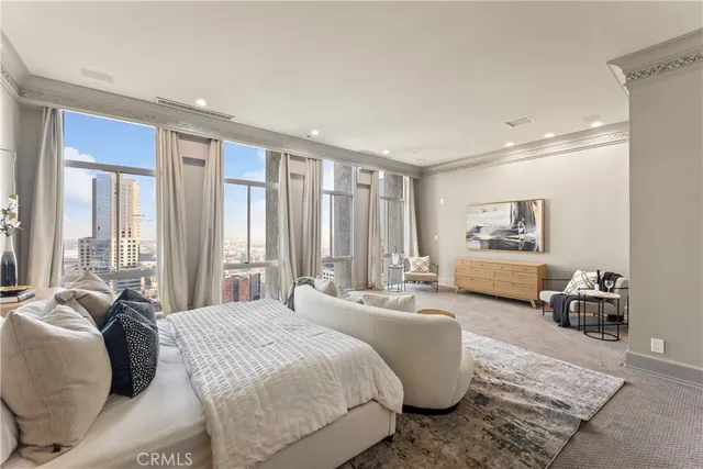 a spacious bedroom with a bed a couch and large window