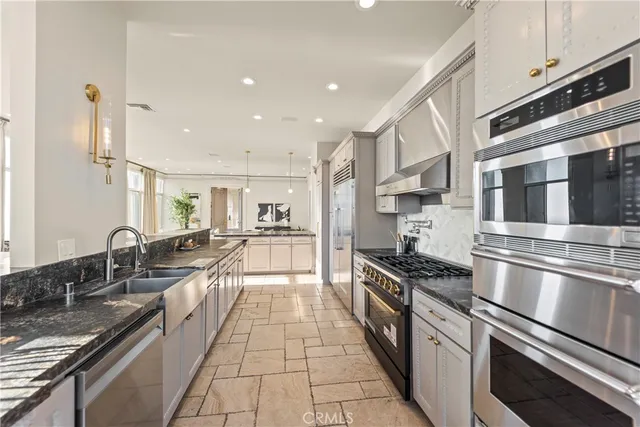 a large kitchen with stainless steel appliances granite countertop a lot of counter space