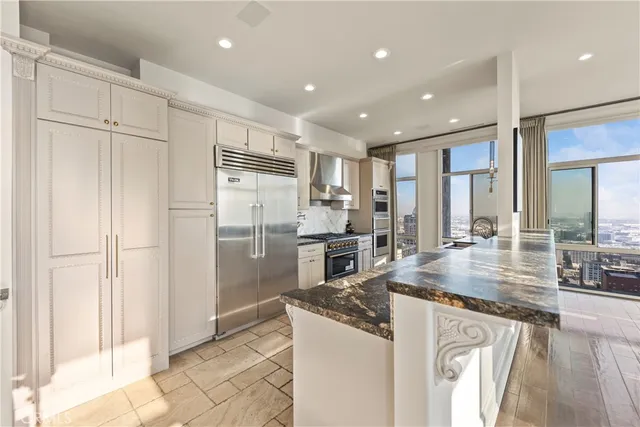 a kitchen with stainless steel appliances granite countertop a refrigerator and a sink