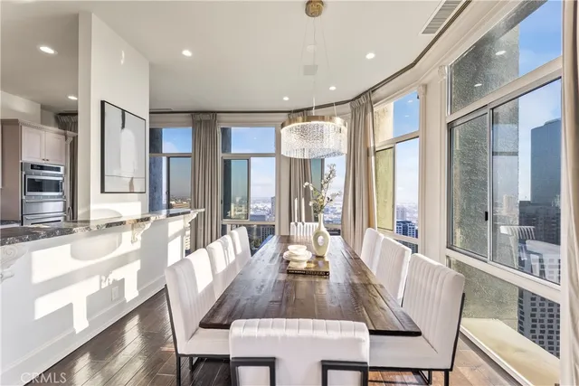 a view of a a dining room with furniture window and wooden floor