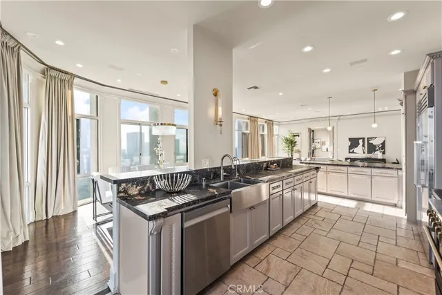 a kitchen with granite countertop a sink and white cabinets