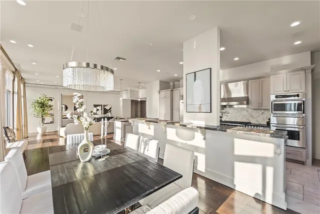 a kitchen with stainless steel appliances kitchen island granite countertop a stove and white cabinets