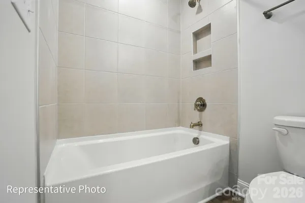 a white bath tub sitting next to a toilet