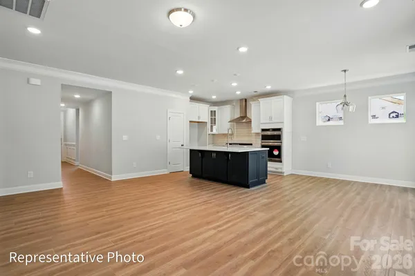 a large kitchen with stainless steel appliances granite countertop a large counter top and wooden floors