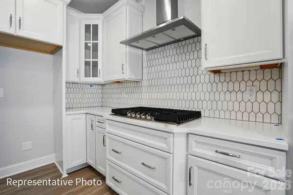 a kitchen with granite countertop white cabinets and white appliances
