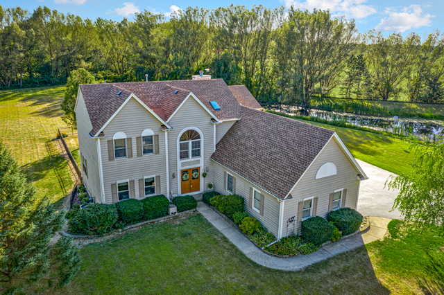 14N600 Timber Ridge Drive Elgin, IL 60124 - Photo 1 of 28 a aerial view of a house next to a yard with plants and large trees