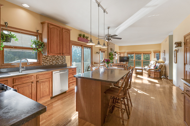 14N600 Timber Ridge Drive Elgin, IL 60124 - Photo 13 of 28 a kitchen with stainless steel appliances kitchen island granite countertop a table chairs in it and wooden floors