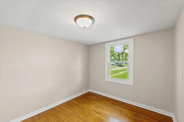 a view of a room with wooden floor and window