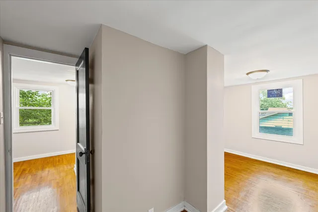 a view of an empty room with a window and a mirror