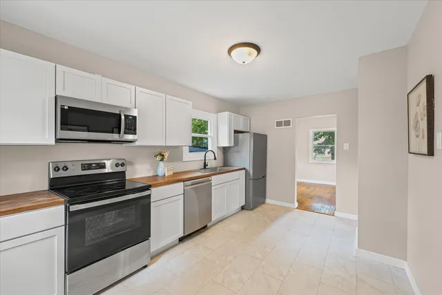 a kitchen with stainless steel appliances a stove sink microwave and refrigerator