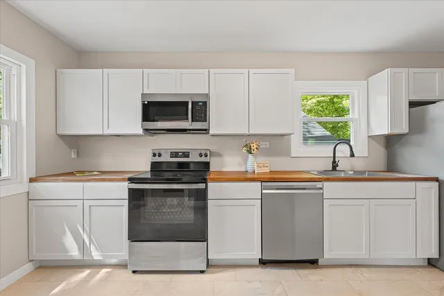 a kitchen with granite countertop white cabinets and a stove