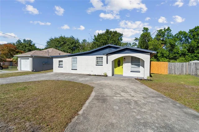 a view of a house with backyard and trees