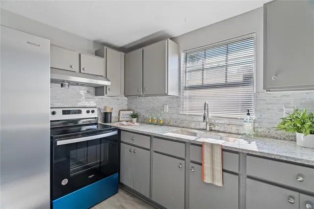a kitchen with stainless steel appliances granite countertop a sink stove oven and white countertops with cabinets