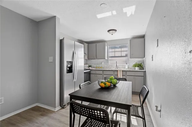 a kitchen with a table chairs and refrigerator