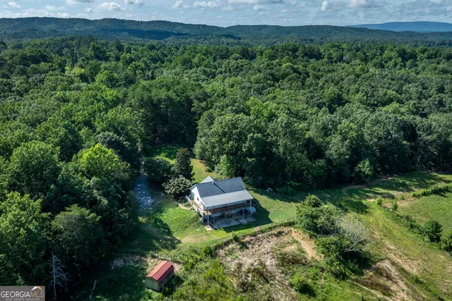 an aerial view of a house with a yard table and chairs