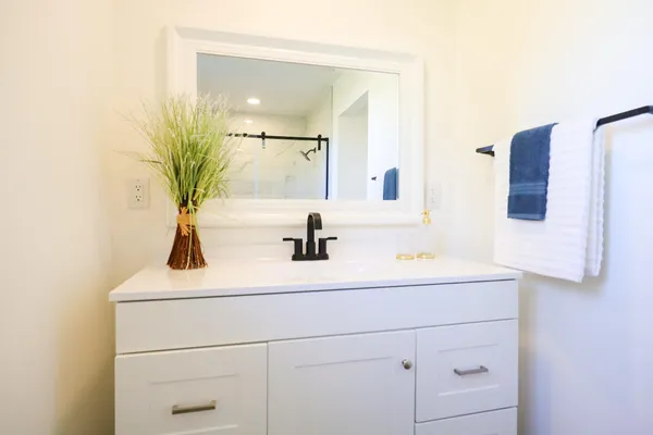 a bathroom with a sink vanity granite and a mirror