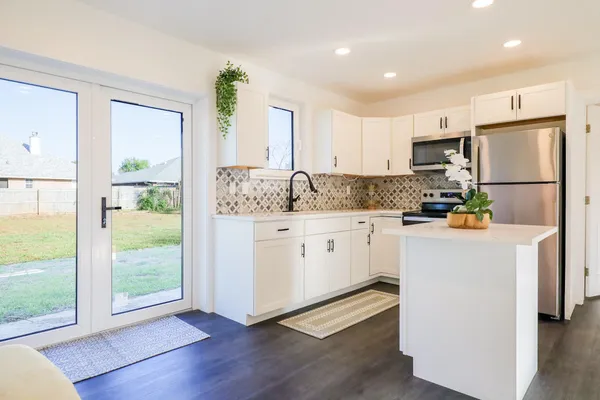 a kitchen with white cabinets and white appliances