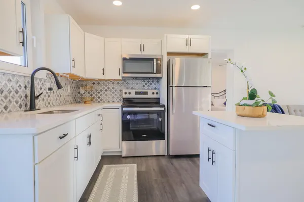 a kitchen with white cabinets and stainless steel appliances