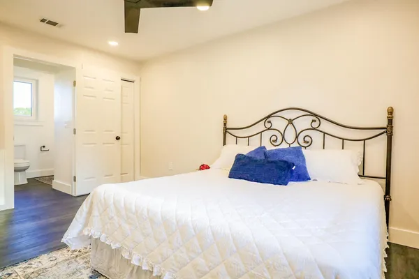 a bedroom with a bed and painting on the wall