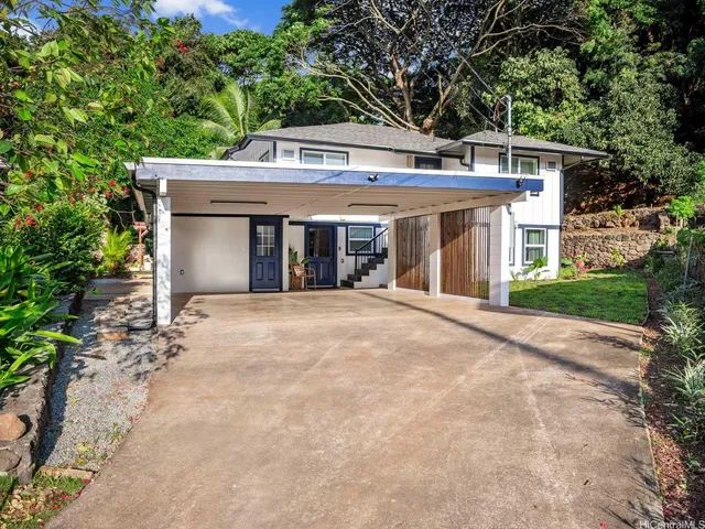a front view of a house with a yard and trees