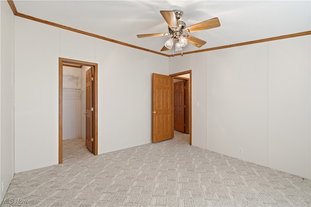 60602 Shaw Road Cambridge, OH 43725 - Photo 28 of 41 Spare room featuring ornamental molding, light carpet, and a ceiling fan