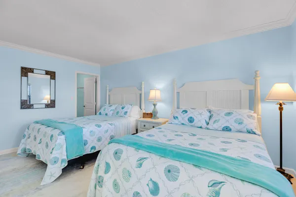 a bedroom with two beds and a lamp