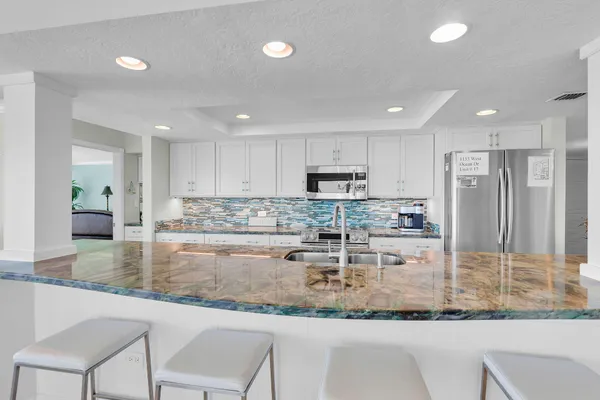 a kitchen with kitchen island granite countertop a counter top space cabinets and stainless steel appliances