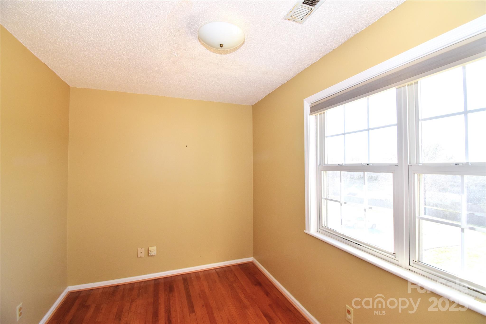233 Ledbetter Road Arden, NC 28704 - Photo 18 of 45 a view of an empty room with wooden floor and a window