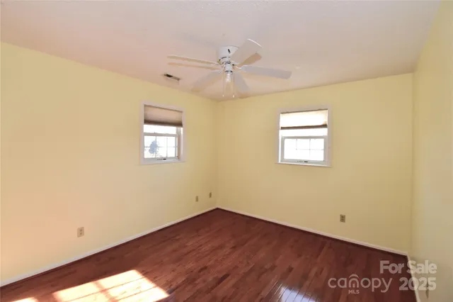 an empty room with a window and wooden floor