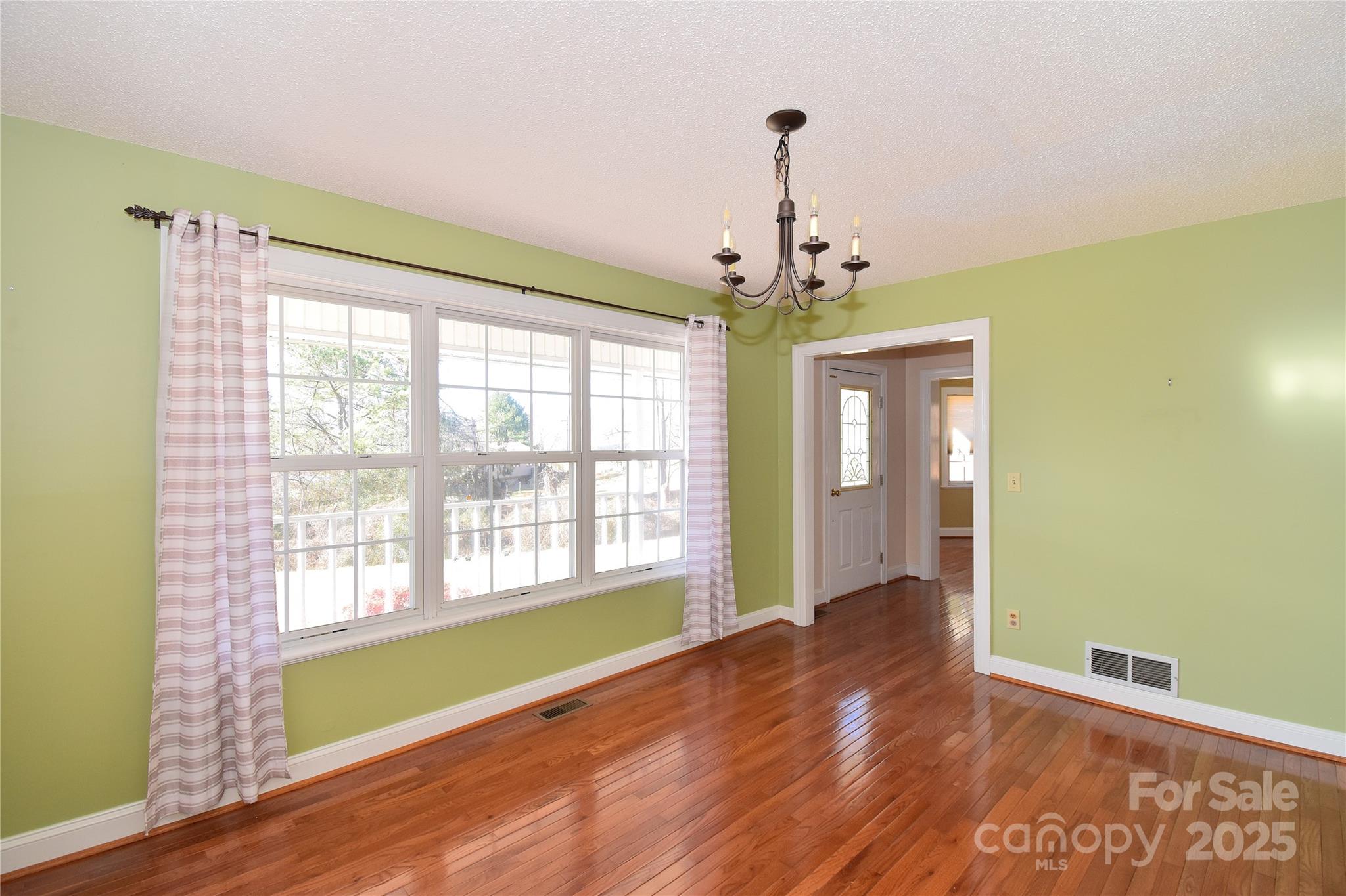 233 Ledbetter Road Arden, NC 28704 - Photo 5 of 45 a view of an empty room with a window and wooden floor