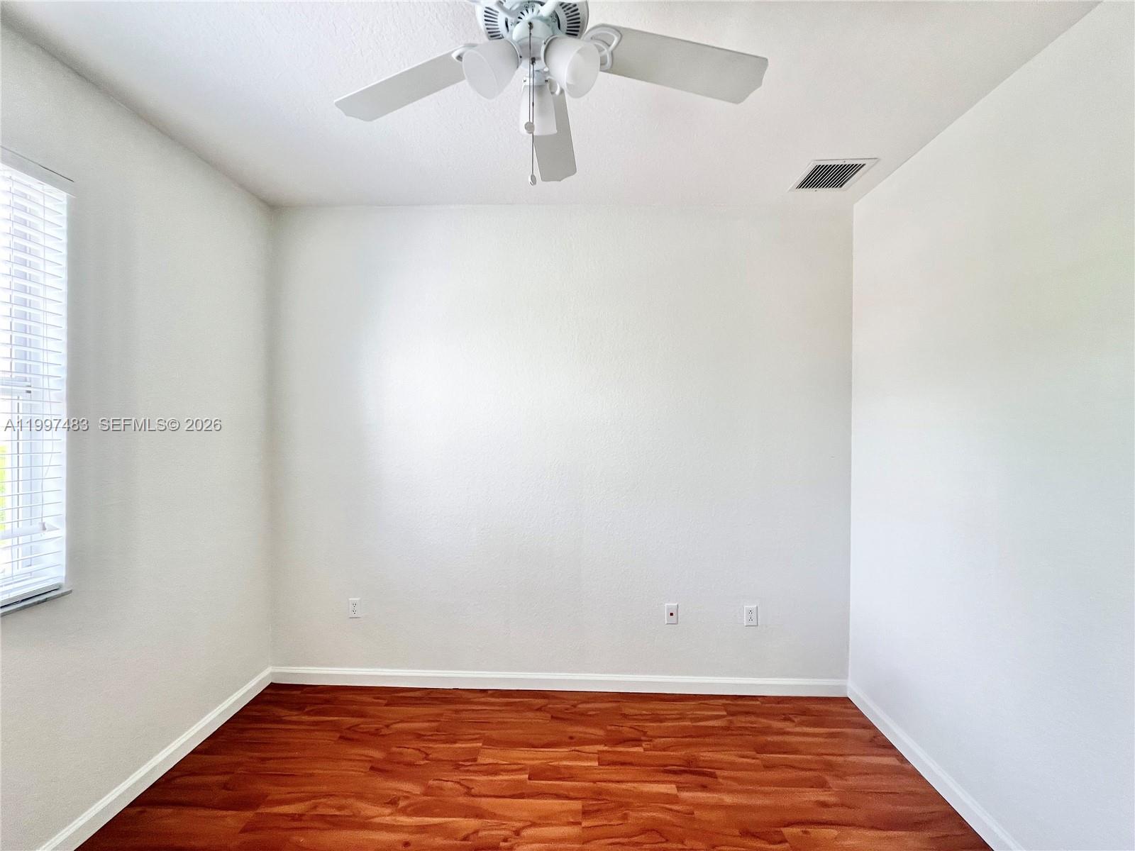 3910 Northeast 13th Drive Homestead, FL 33033 - Photo 19 of 35 a view of room with window and wooden floor
