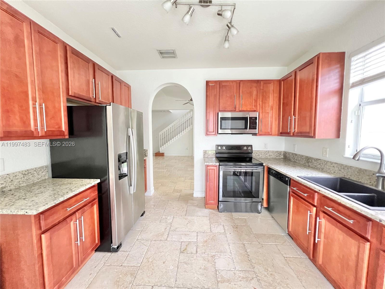 3910 Northeast 13th Drive Homestead, FL 33033 - Photo 4 of 35 a kitchen with stainless steel appliances granite countertop a refrigerator a stove top oven a sink and dishwasher