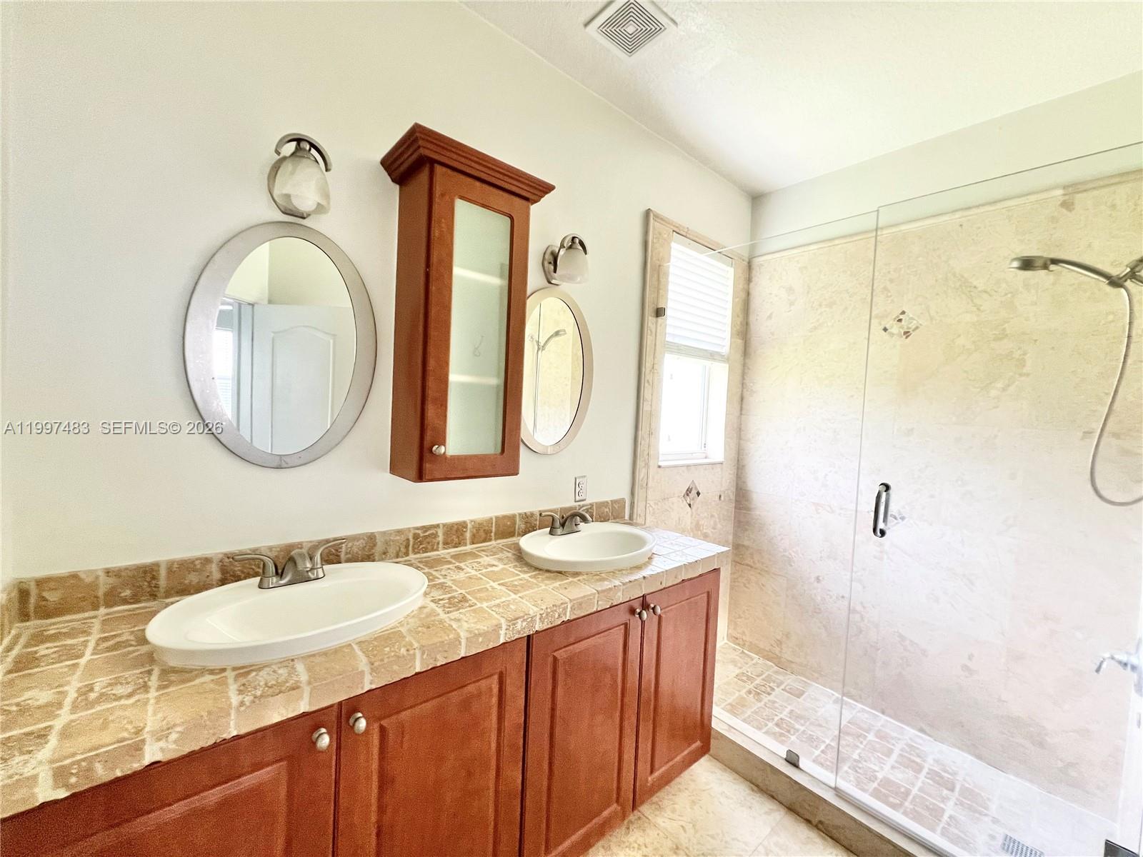 3910 Northeast 13th Drive Homestead, FL 33033 - Photo 6 of 35 a bathroom with a granite countertop double vanity sink and a mirror