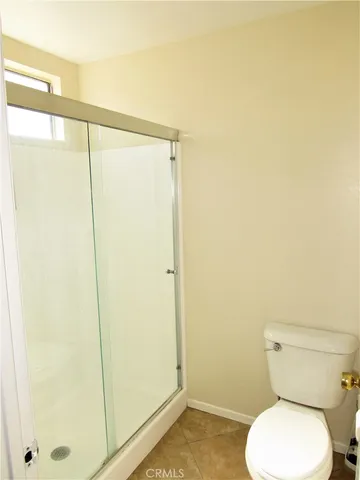 a white toilet sitting next to a shower